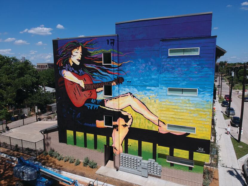 A mural of a woman playing guitar, painted by John Bramblitt.