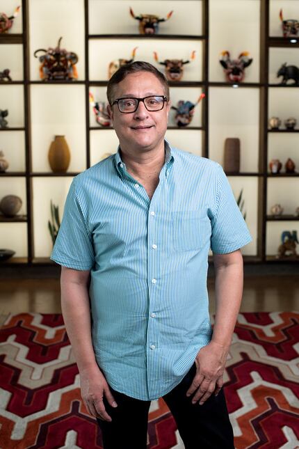 Jorge Baldor, founder of Mercado Artesanal, stands in front of hand-crafted Latin American...