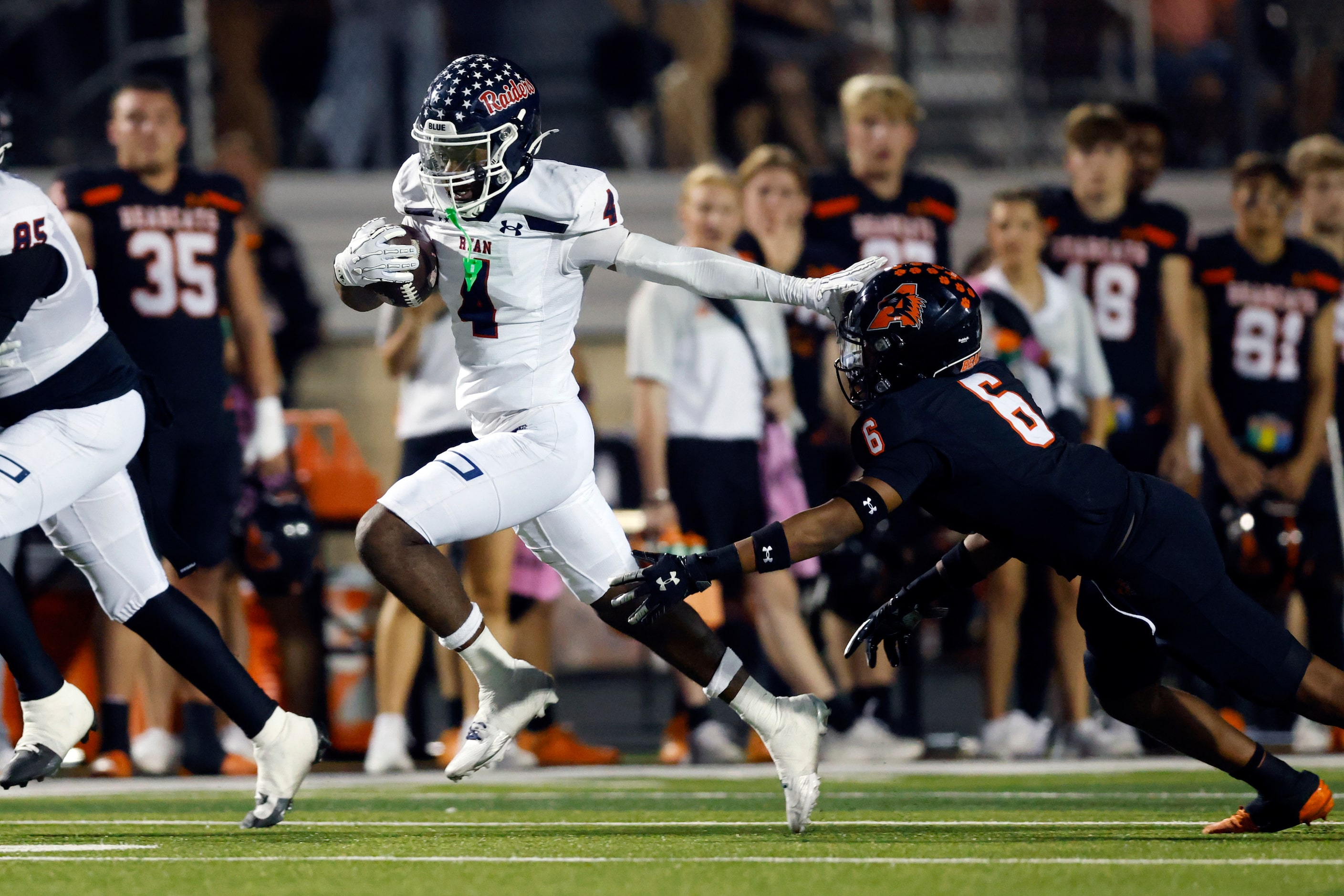 Denton Ryan running back Tre'Vaughn Reynolds (4) slips a tackle from Aledo defensive back...