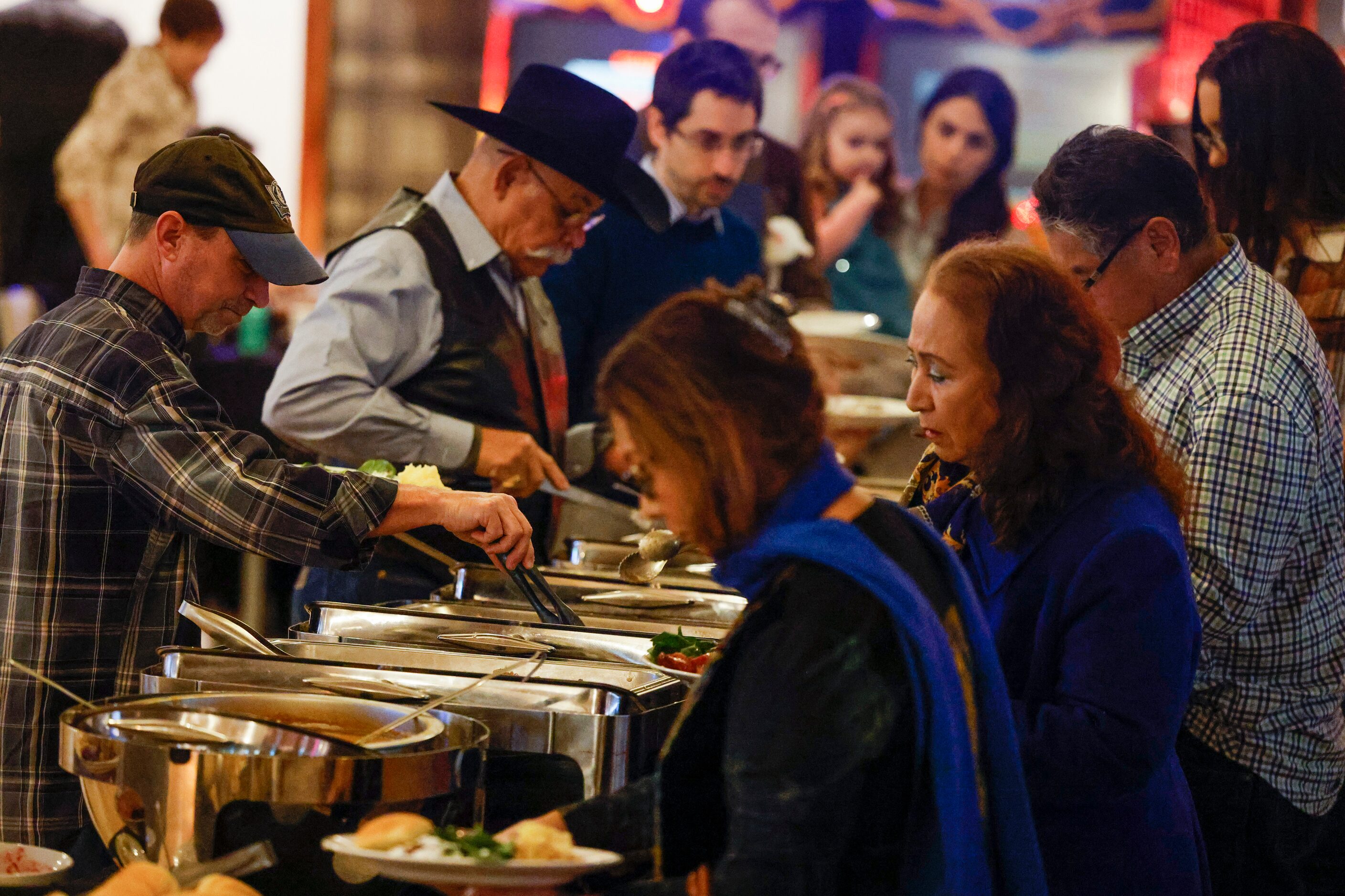 Attendees get in line to get Thanksgiving meal during the fifth annual Thanksgiving dinner...