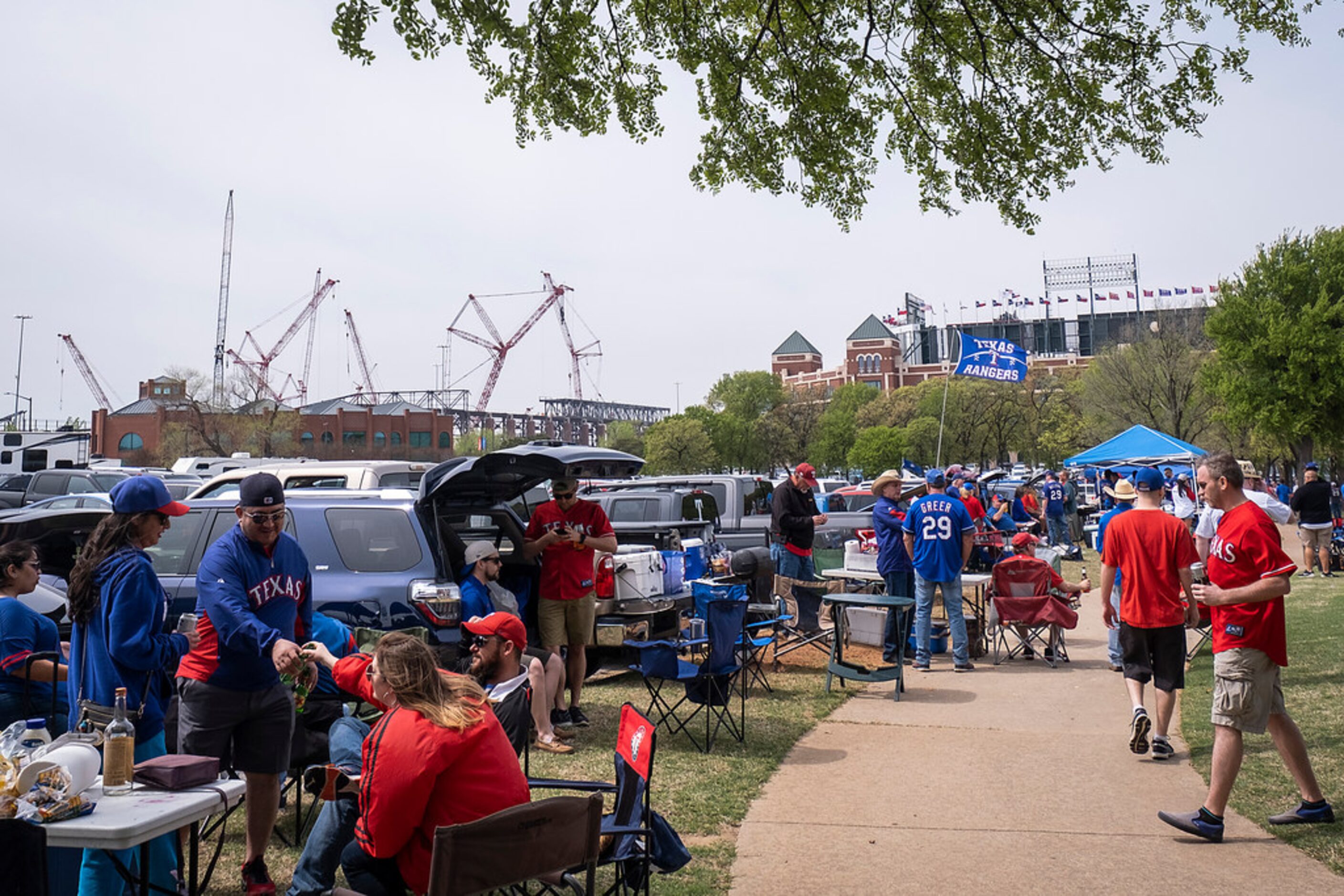 Globe Life Field rises to the left as Texas Rangers fans tailgate before the Texas Rangers...