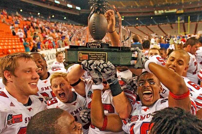  December 24, 2009--SMU players celebrate as they hold the Hawaii bowl trophy after their...