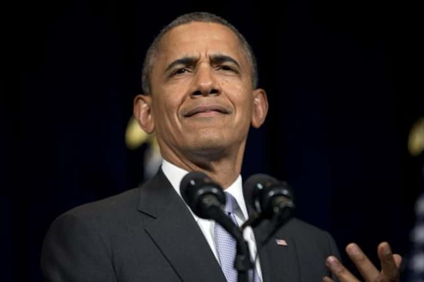 
President Barack Obama reacts as he is interrupted by a heckler in the audience during his...