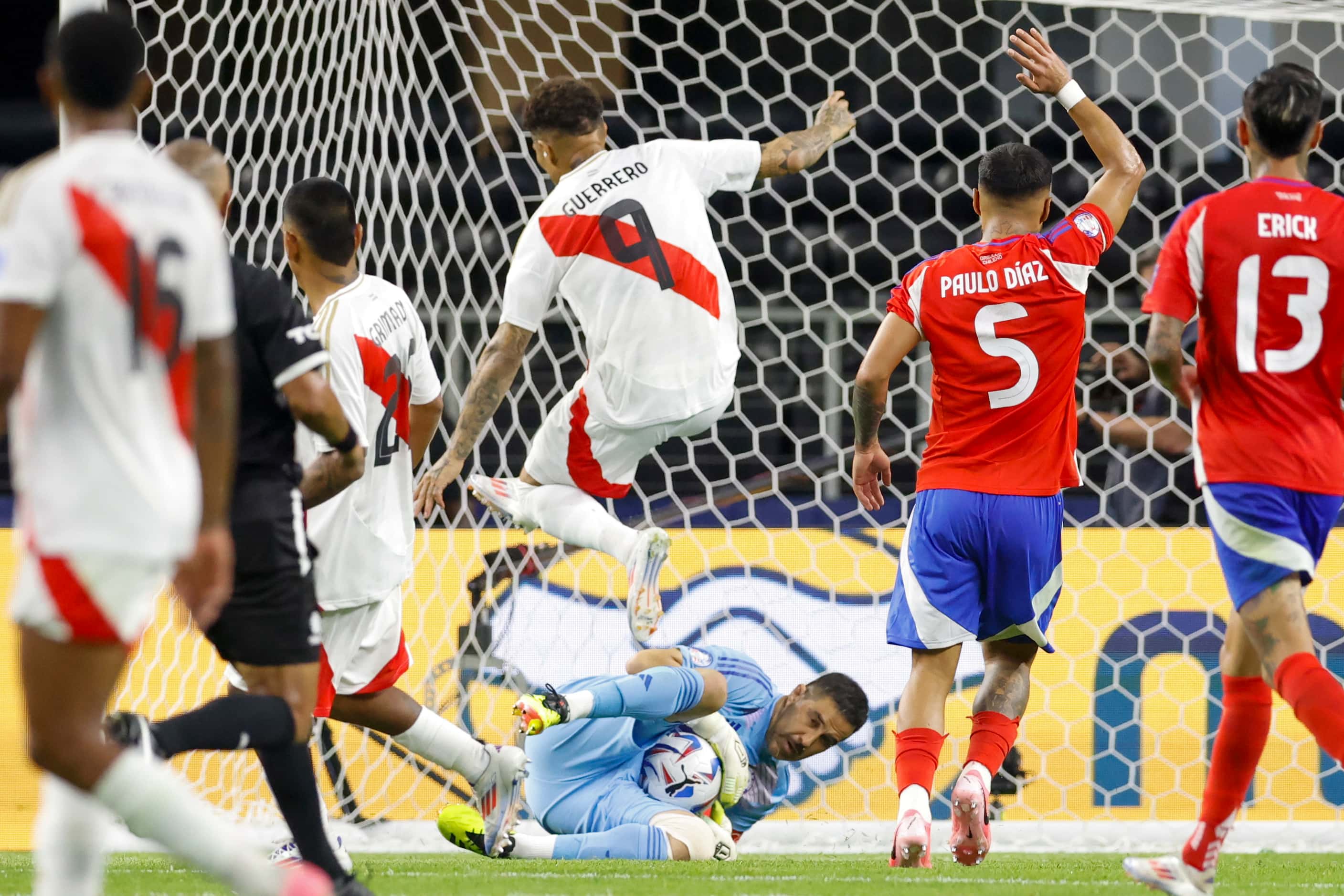 Chile goalkeeper Claudio Bravo (1) slides to make a save as Peru forward José Paolo Guerrero...