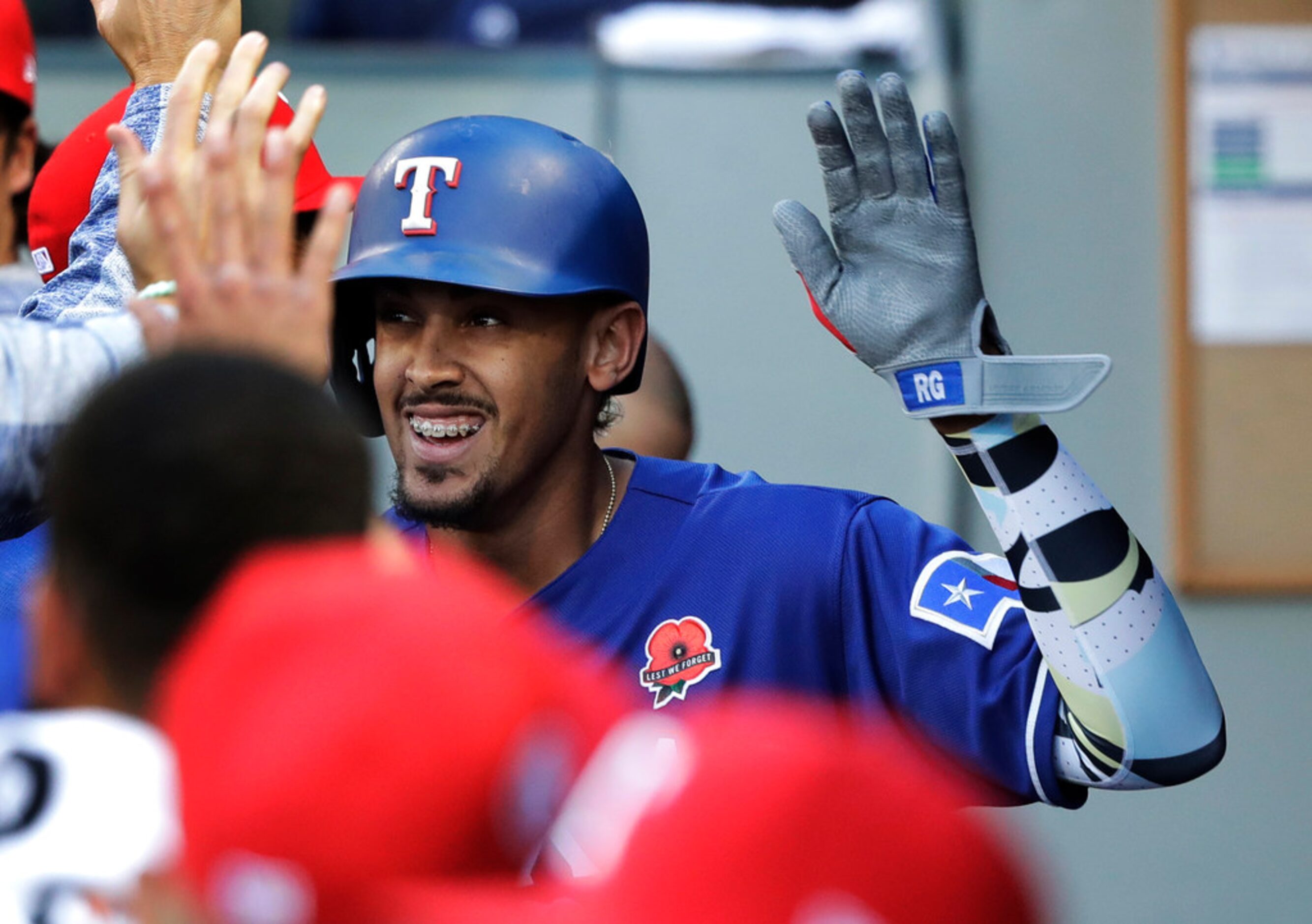 Texas Rangers' Ronald Guzman is greeted in the dugout after he hit a solo home run during...