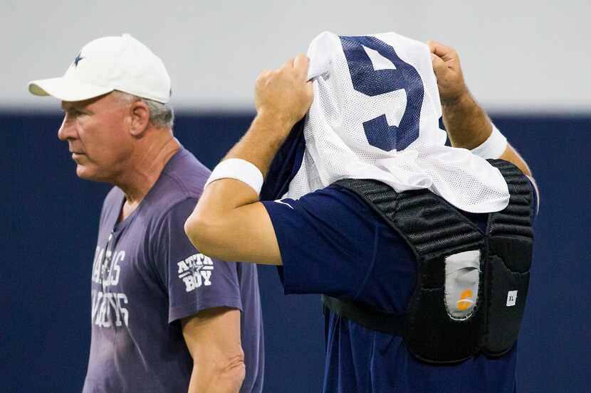 Dallas Cowboys quarterback Tony Romo dons his jersey before taking the field for the team's...