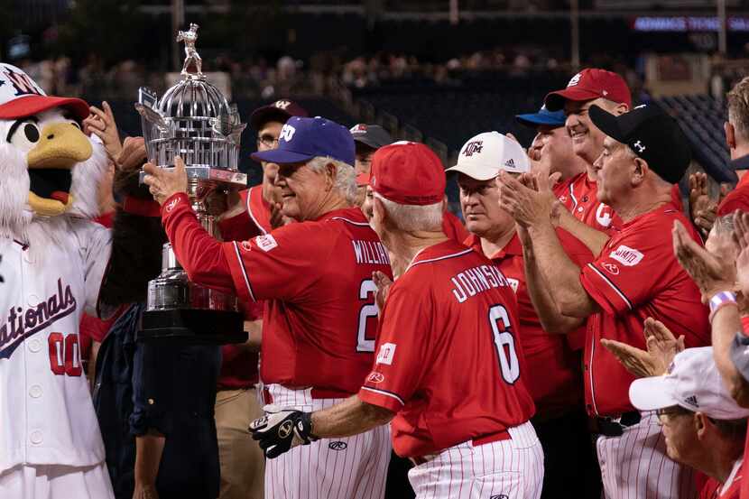 Republican manager Rep. Roger Williams, R-Texas, holds the trophy after the GOP beat the...