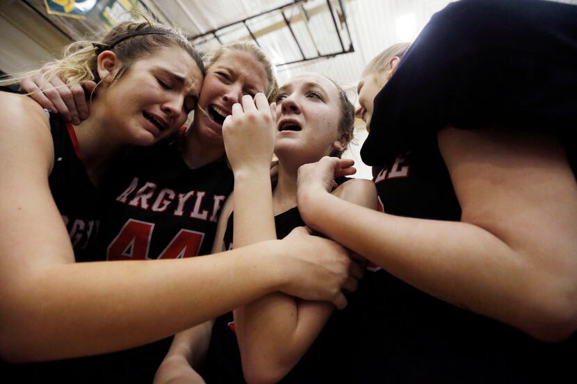 Argyle sophomore guard Rhyle McKinney (5), third from left, is congratulated by teammates...