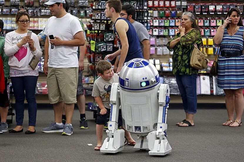 Thomas Howard, 7, of Allen checks out an R2D2 model which took Jeff Koenig of Garland two...