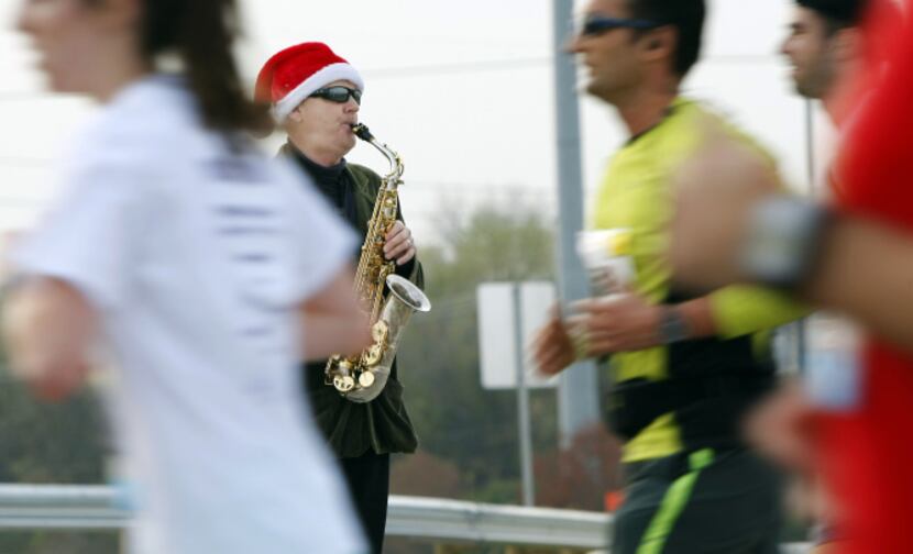 Saxophonist 'Slimey Lemon' plays as runners make their way across the Margaret Hunt Hill...