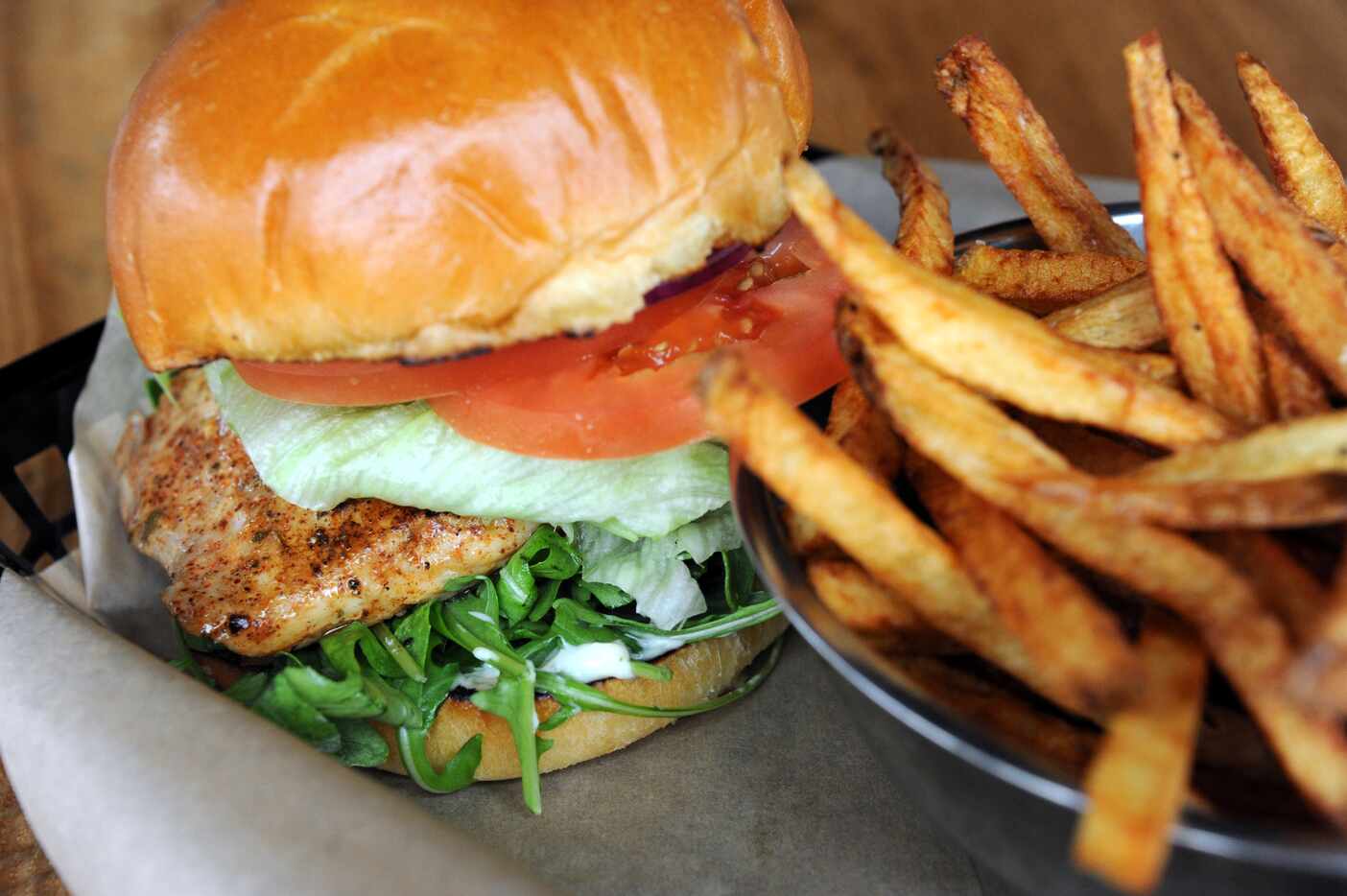 The gulf fish sandwich features mahi tuna with tomato, lettuce, and arugula at Spork in Dallas.