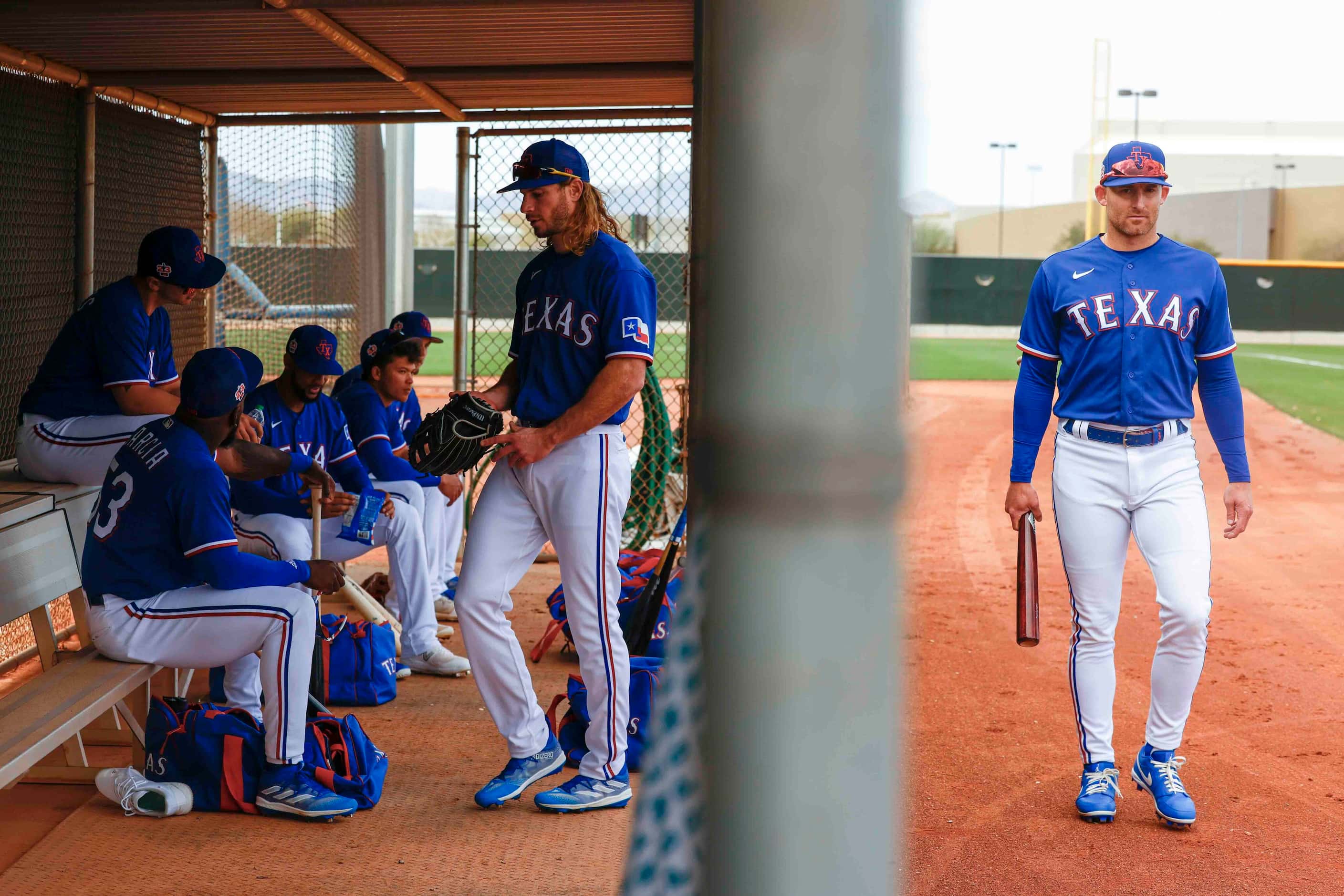 Texas Rangers outfielder Brad Miller, right, walks back to the dugout during a spring...