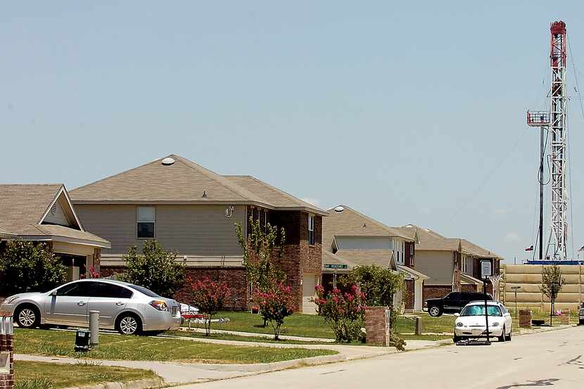 A Devon Energy rig rises above the Remington Park subdivision in Ponder, Texas.