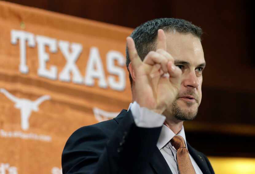 Tom Herman holds up the Hook 'em Horns sign during a news conference where he was introduced...