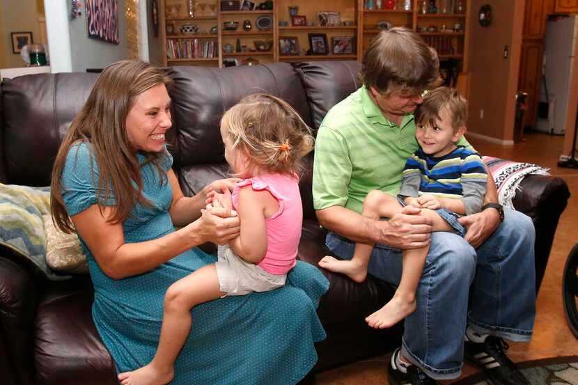 
Julie Armstrong and Nathan Anderson of Tucson play with their children, who may need to...