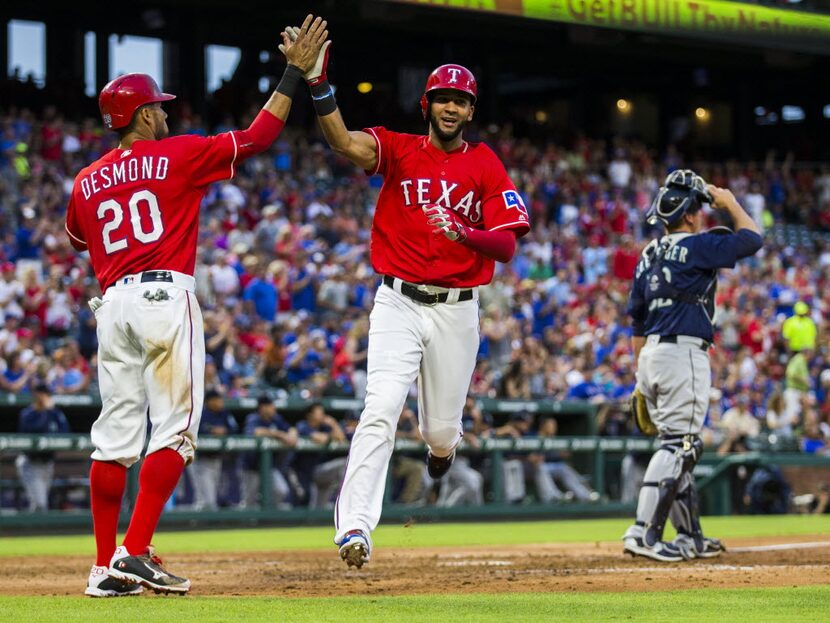 Texas Rangers left fielder Ian Desmond (20) and right fielder Nomar Mazara (30) high-five...