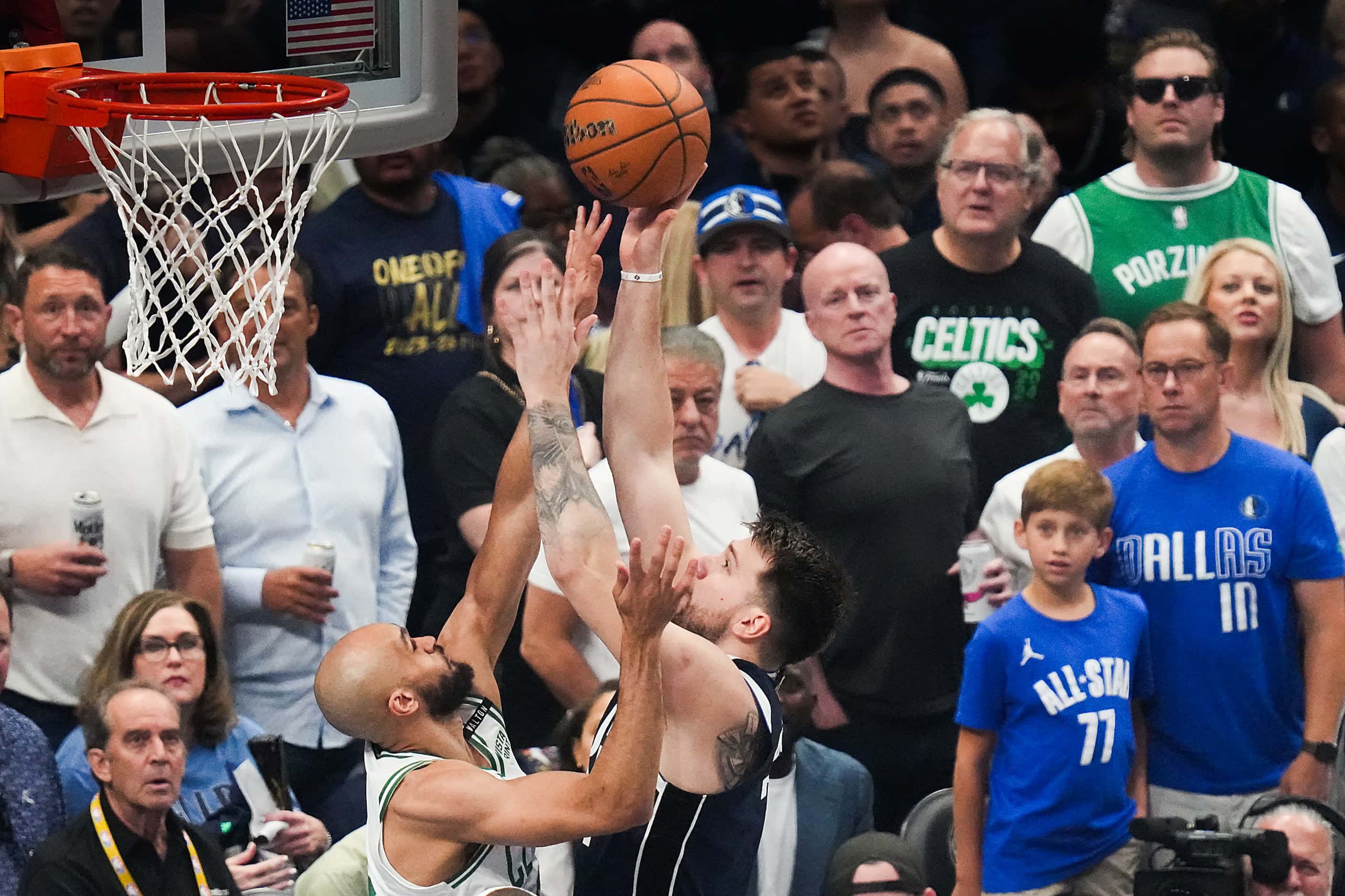 Dallas Mavericks guard Luka Doncic (77) scores past Boston Celtics guard Derrick White (9)...