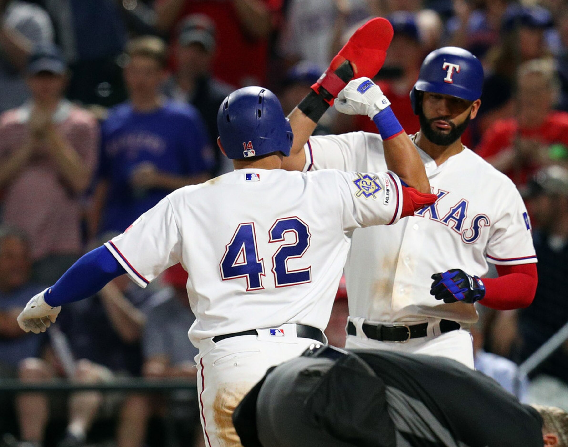 ARLINGTON, TEXAS - APRIL 15: Asdrubal Cabrera #14 is greeted at the plate by Nomar Mazara...