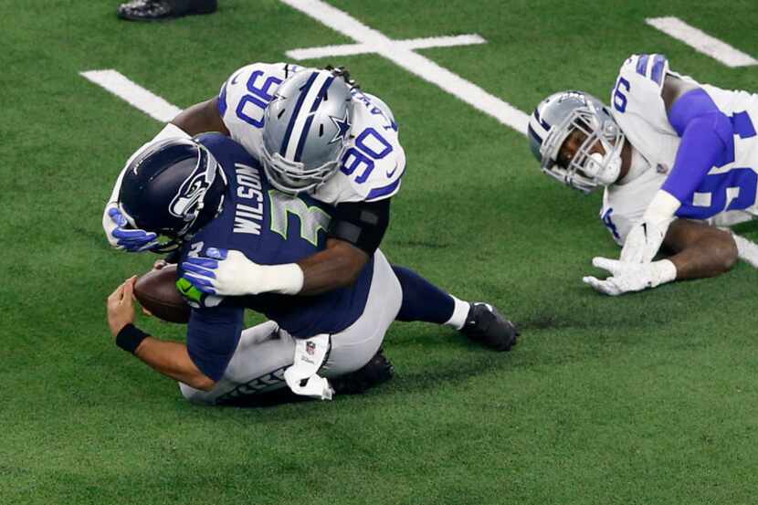 FILE - Dallas Cowboys defensive end Demarcus Lawrence (90) tackles Seattle Seahawks...