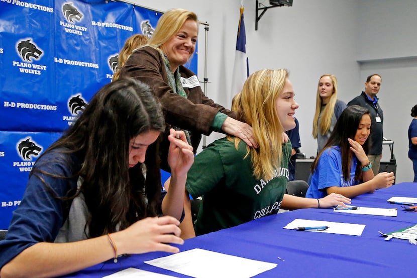 Soccer player Karina Williams (left) signs with Palm Beach Atlantic University while Mariel...