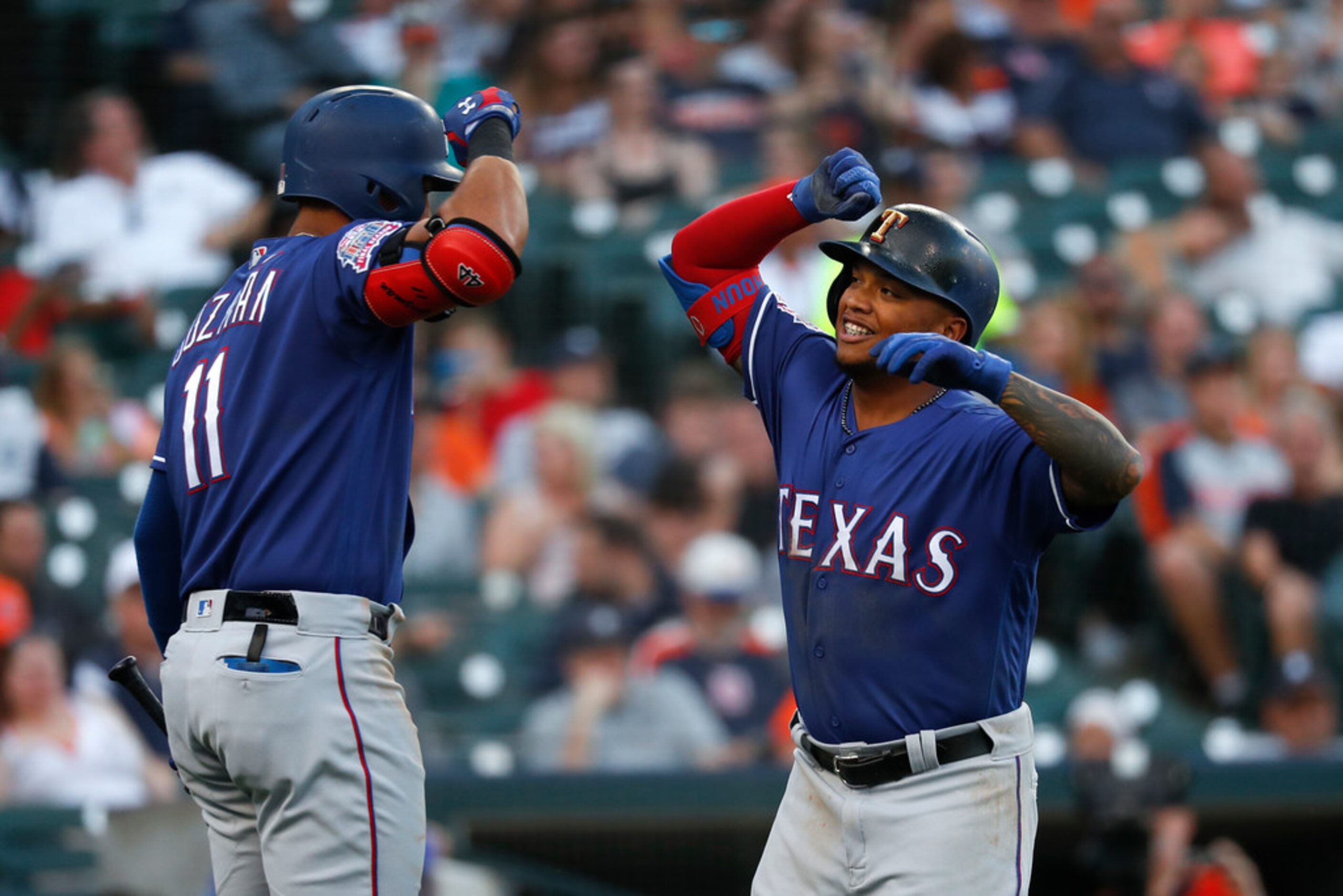 Texas Rangers' Willie Calhoun, right, celebrates his solo home run with Ronald Guzman in the...