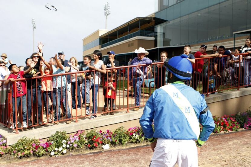 Jockey Richard E. Eramia throws his goggles to the crowd after winning the handicap race on...