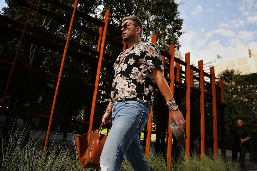 Reed Robertson, of Dallas, walks to work at Forty Five Ten along Elm Street while The Dallas...