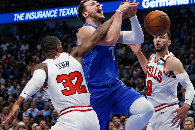 Dallas Mavericks forward Luka Doncic (77) is blocked as he goes up for a shot past Chicago...
