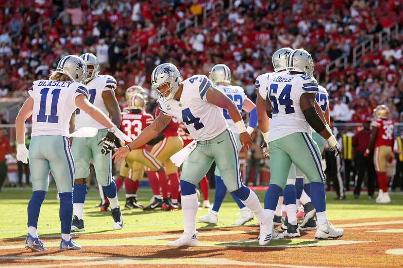 Dallas Cowboys quarterback Dak Prescott (4) celebrates with wide receiver Cole Beasley (11)...
