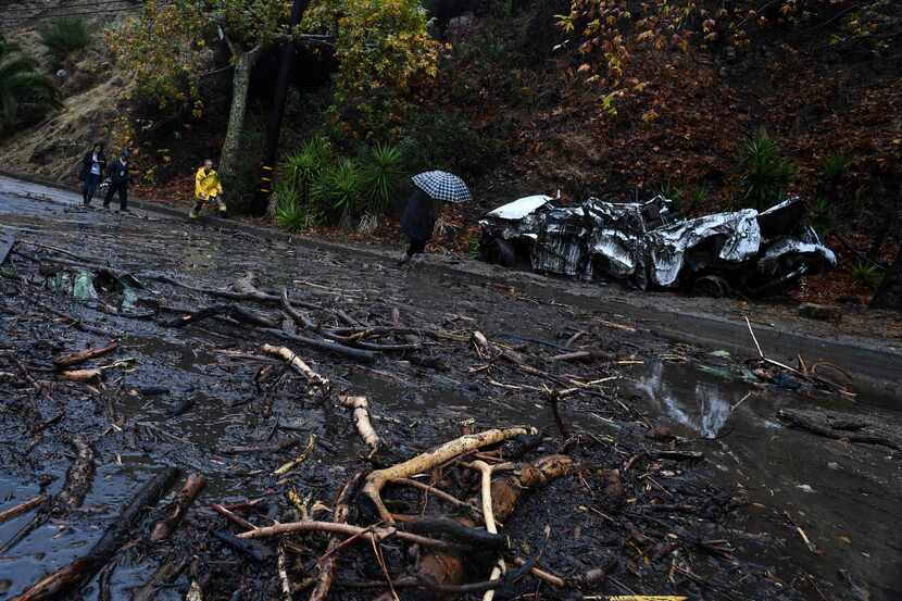 A firefighter (in yellow) instructs journalists to retreat to safer ground after a...