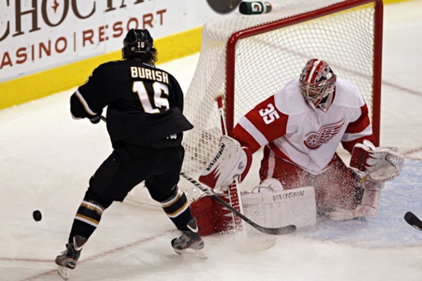 Detroit goalie Jimmy Howard (right) blocks a shot by Dallas right wing Adam Burish during...