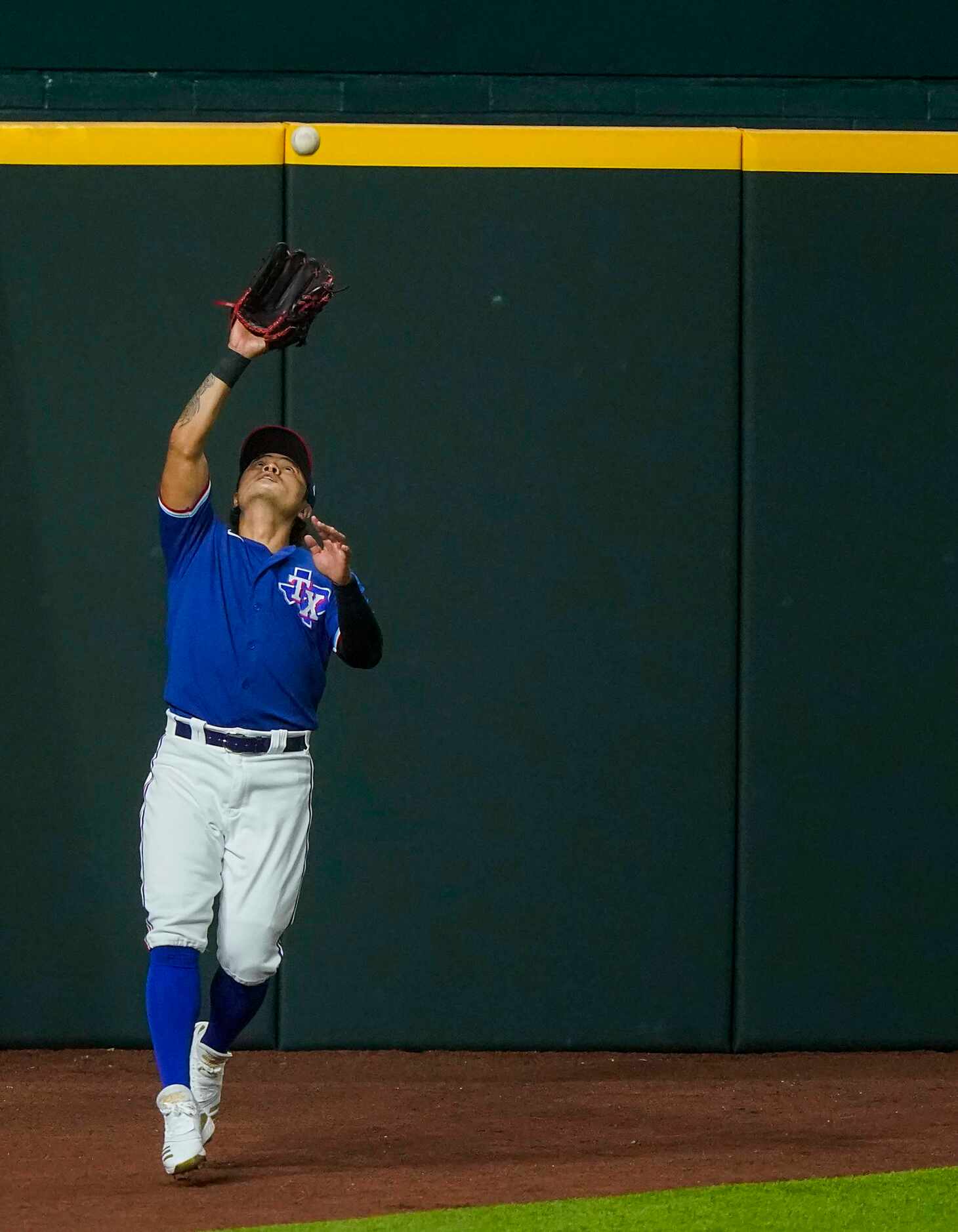 Texas Rangers outfielder Shin-Soo Choo makes a catch on the left field warning track on a...