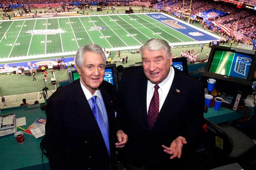 Fox broadcasters Pat Summerall, left, and John Madden stand in the broadcast booth at the...
