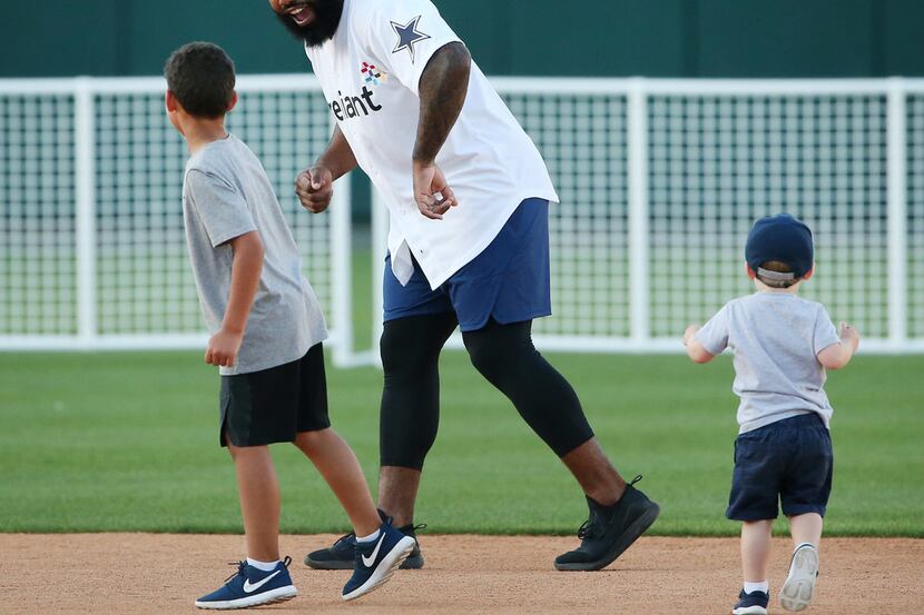 Dallas Cowboys running back Ezekiel Elliott runs with children on the field after the...