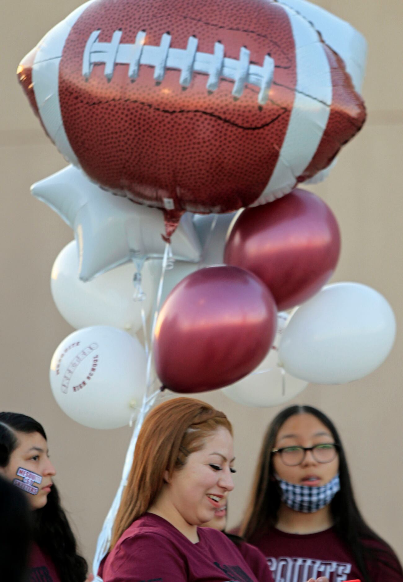 A Mesquite High senior’s family member checks her smartphone under balloons she’s brought...