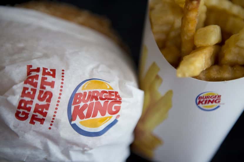 A Burger King Worldwide Inc. Whopper hamburger and Satisfries are arranged for a photograph...