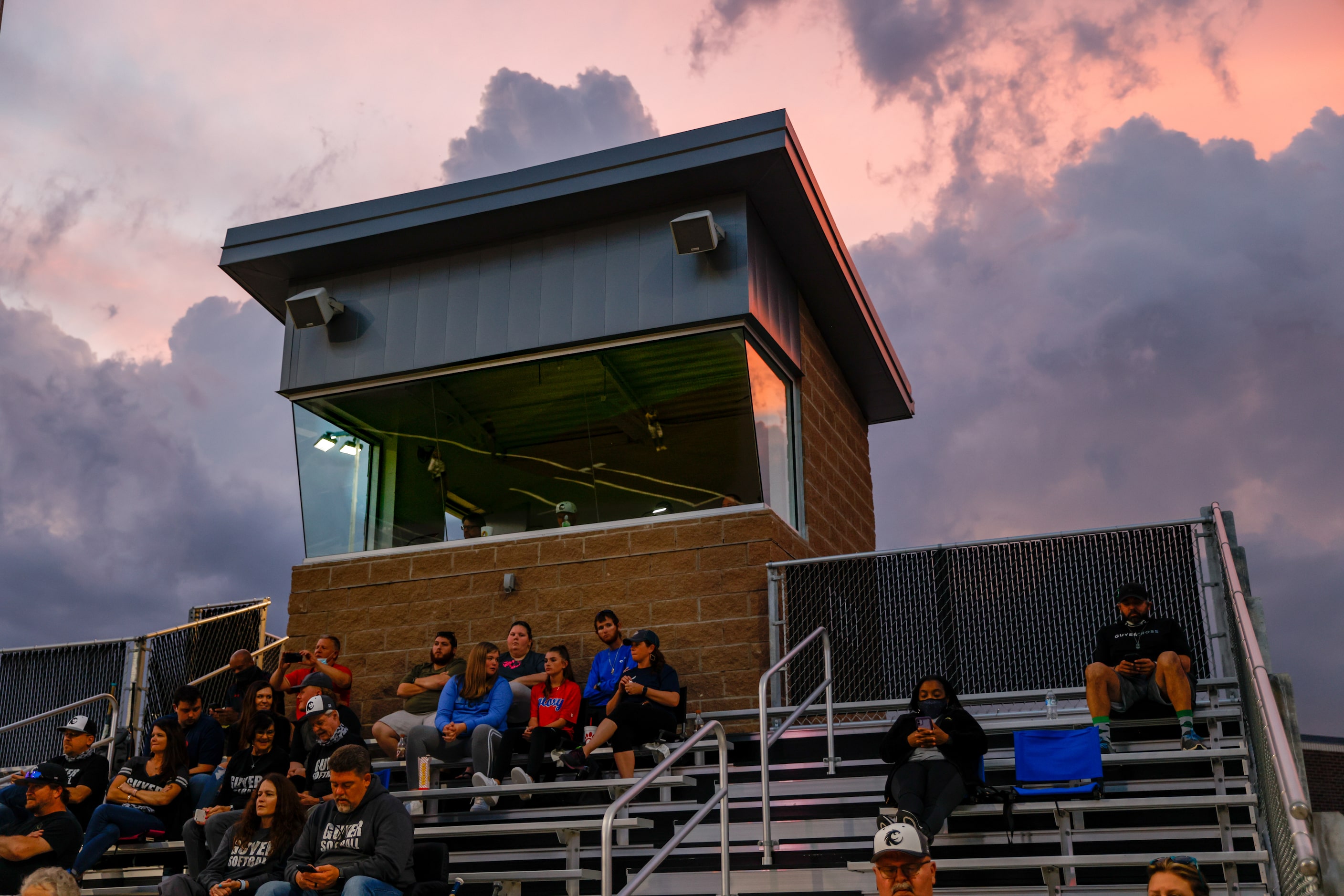 The sun sets as fans watch a nondistrict high school softball game between Denton Guyer and...