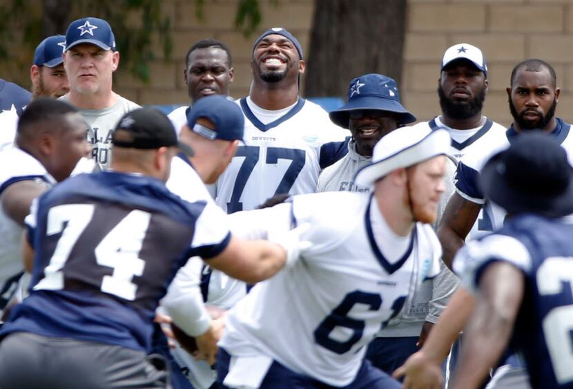 Dallas Cowboys tackle Tyron Smith (77) smiles as a play goes on at the morning walk through...
