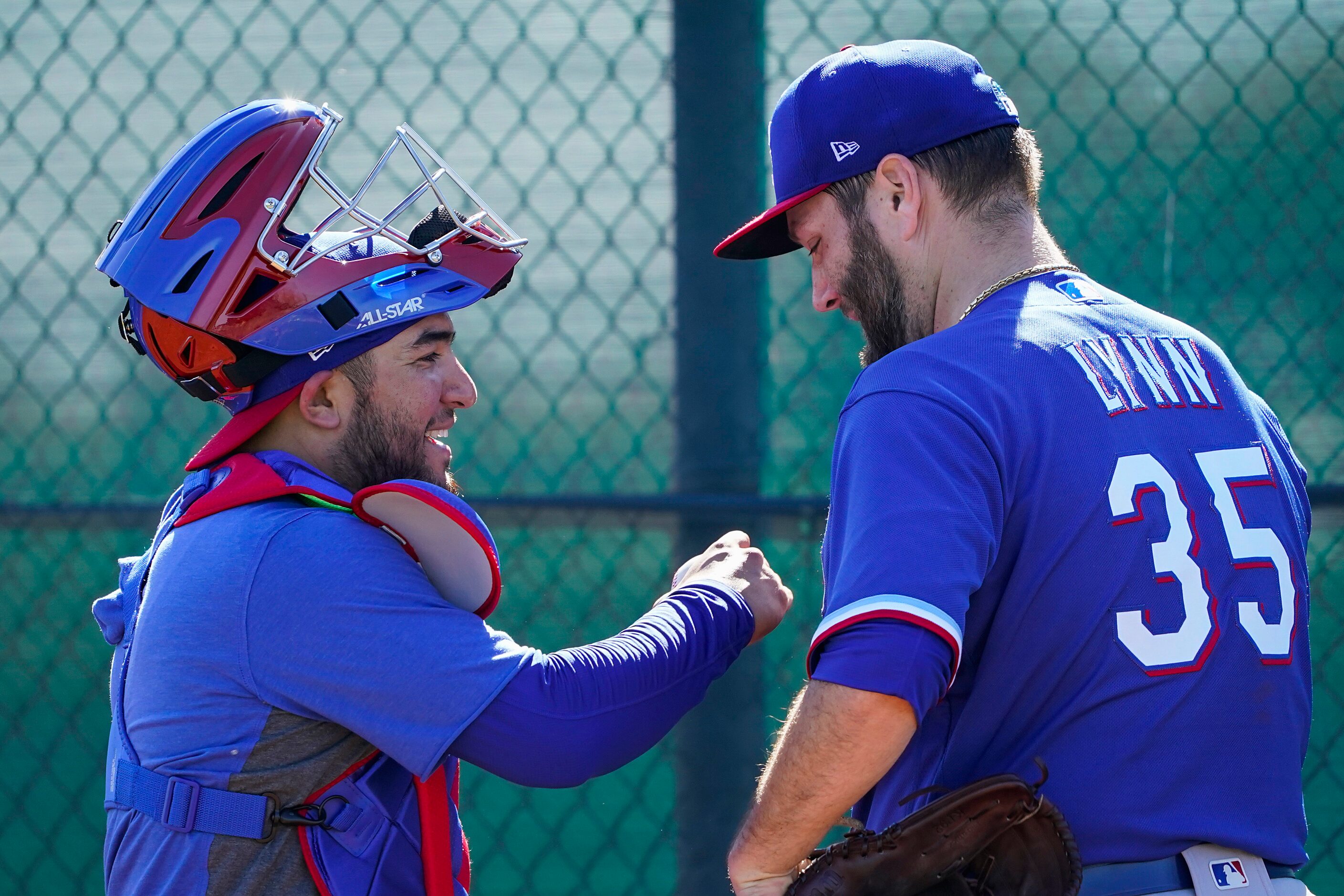 Texas Rangers catcher Jose Trevino fist bumps pitcher Lance Lynn after a bullpen session...