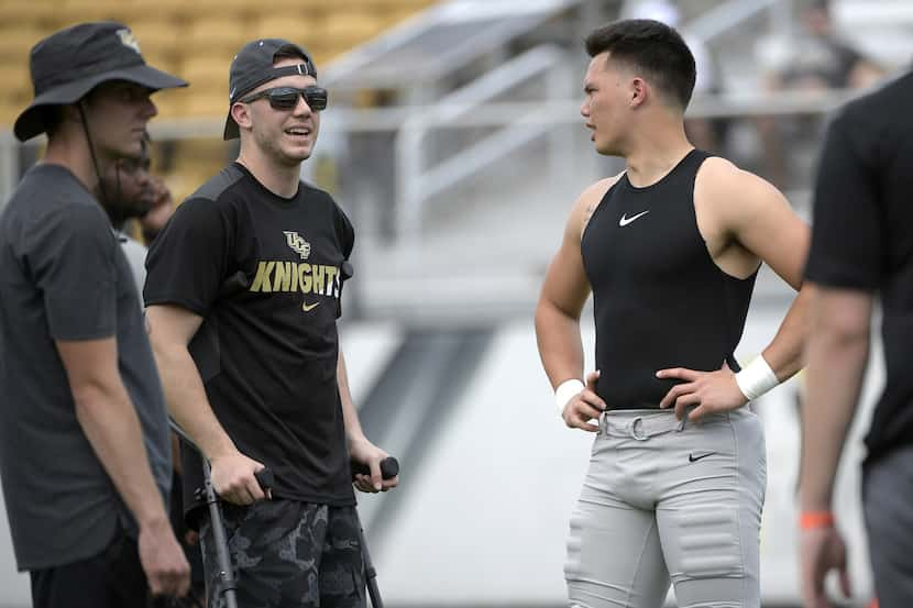 Central Florida quarterback Dillon Gabriel, right, chats with quarterback McKenzie Milton,...