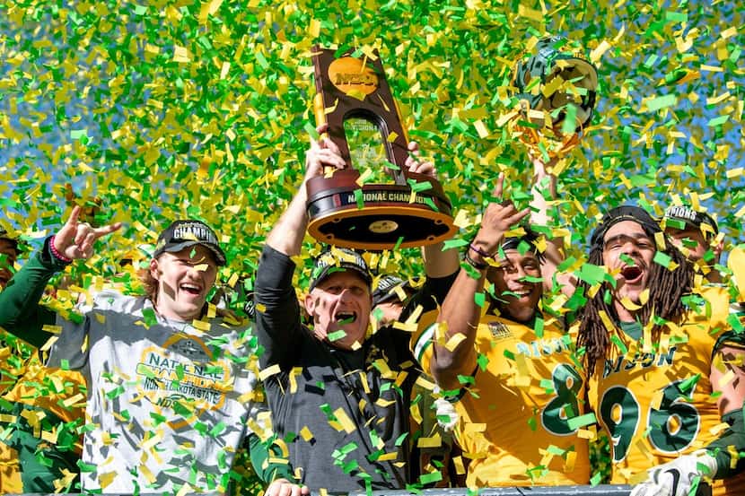 North Dakota State head coach Chris Klieman and his players hoist the trophy after beating...