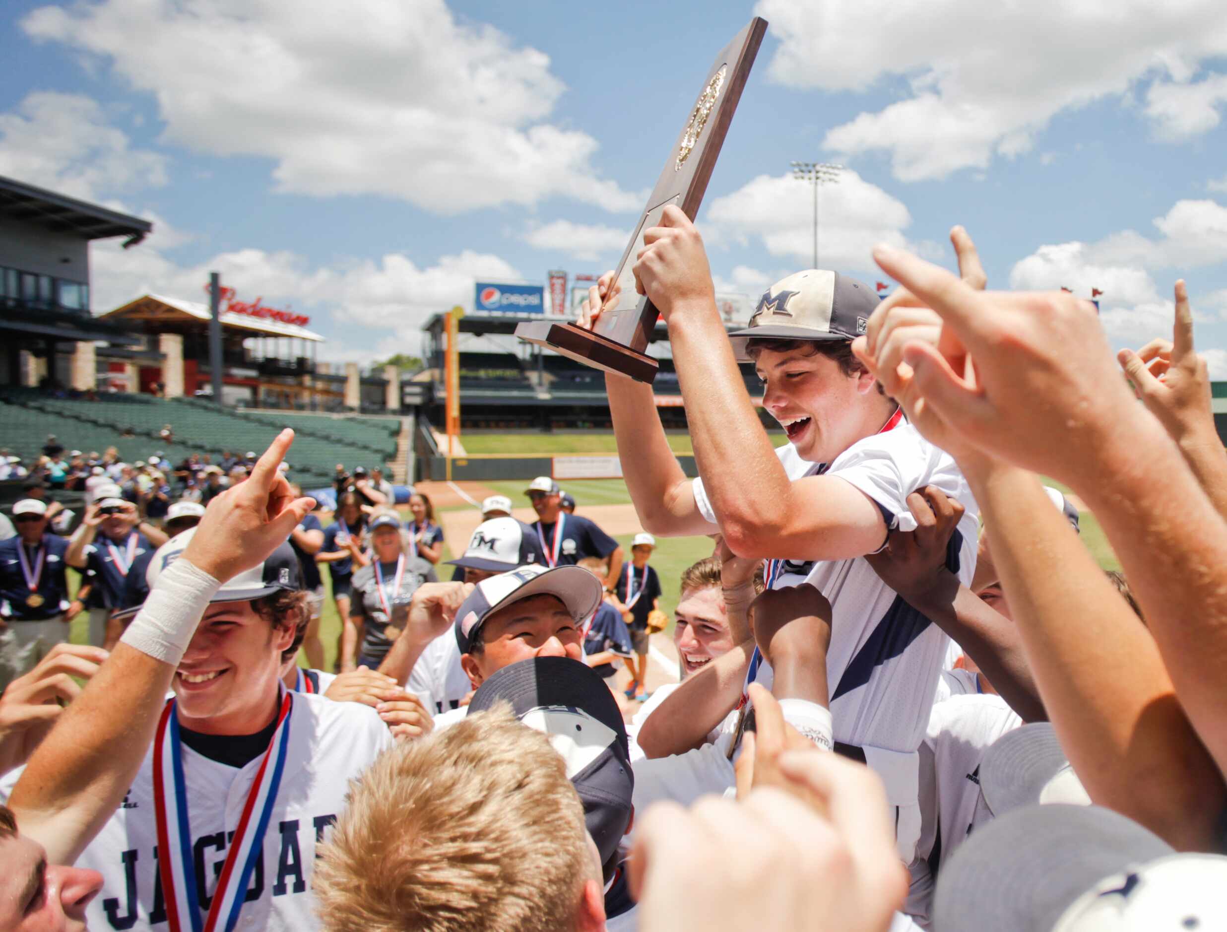 Flower Mound players cheer with the trophy after their win against San Antonio Reagan at...