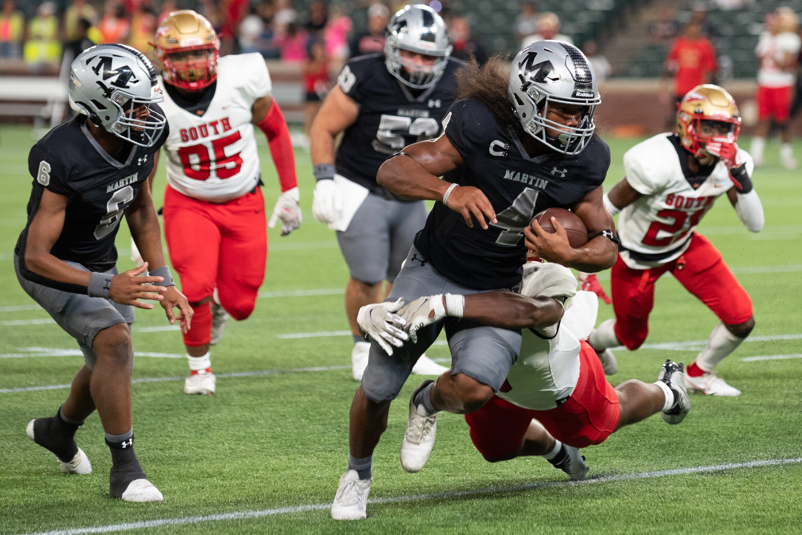 Arlington Martin senior wide receiver Michael Barrow (4) runs with the football for positive...