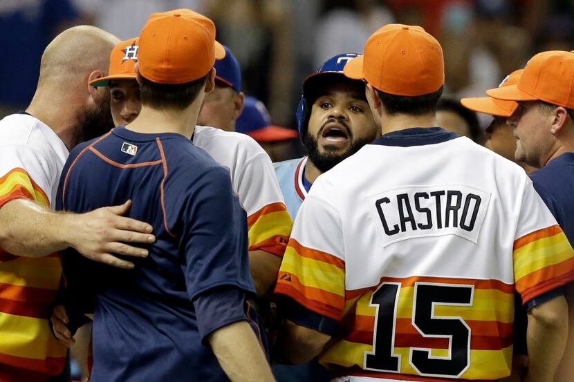 Texas Rangers' Prince Fielder, center, confronts Houston Astros' Jed Lowry, in navy blue,...