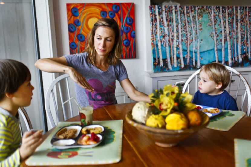 Artist Gina Marie Dunn discusses a painting with her two sons Callum Dunn, 4, left, and Mack...