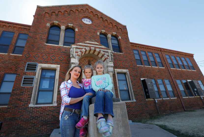 Amanda Litteken, with daughters Charlie, 5, and Brianne, 7, pose for a portrait in front of...