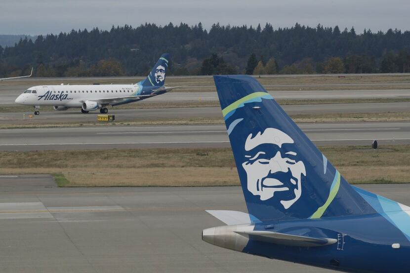 A passenger plane with SkyWest Airlines, left, a regional airline under contract with Alaska...
