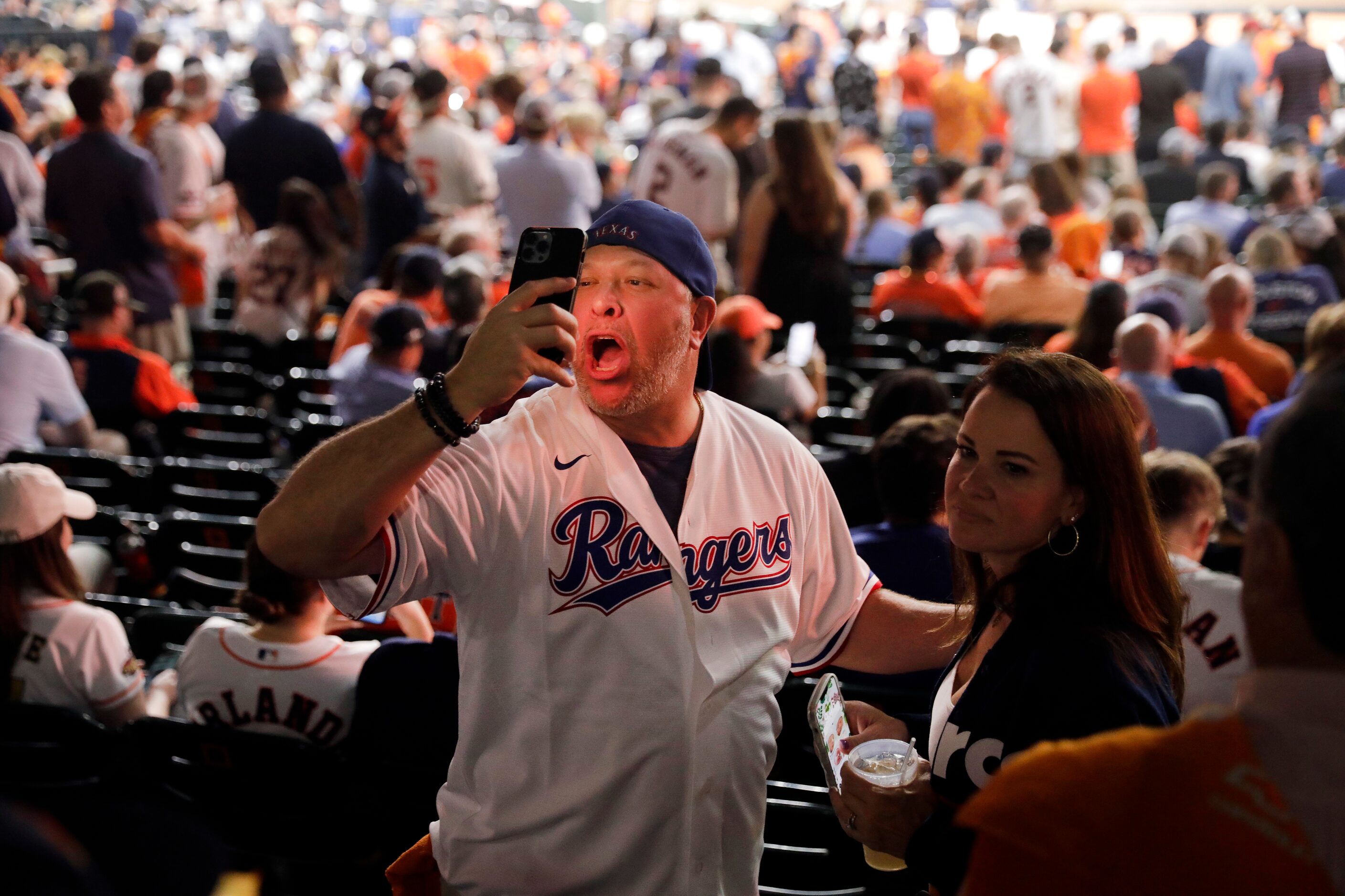 A Texas Rangers fan talks to a friend on face time during Game 7 of the American League...