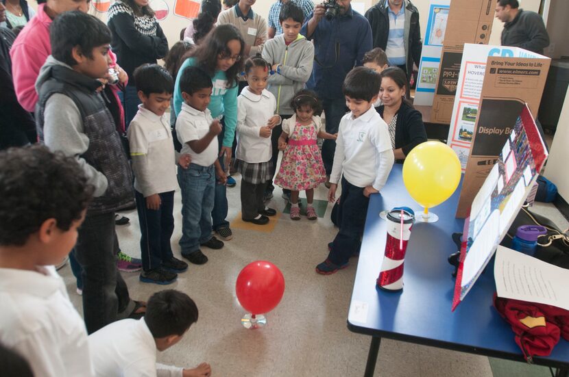 Siddarth Balaji,5, right, demonstrates his science project of a hovercrafts made of cd's and...