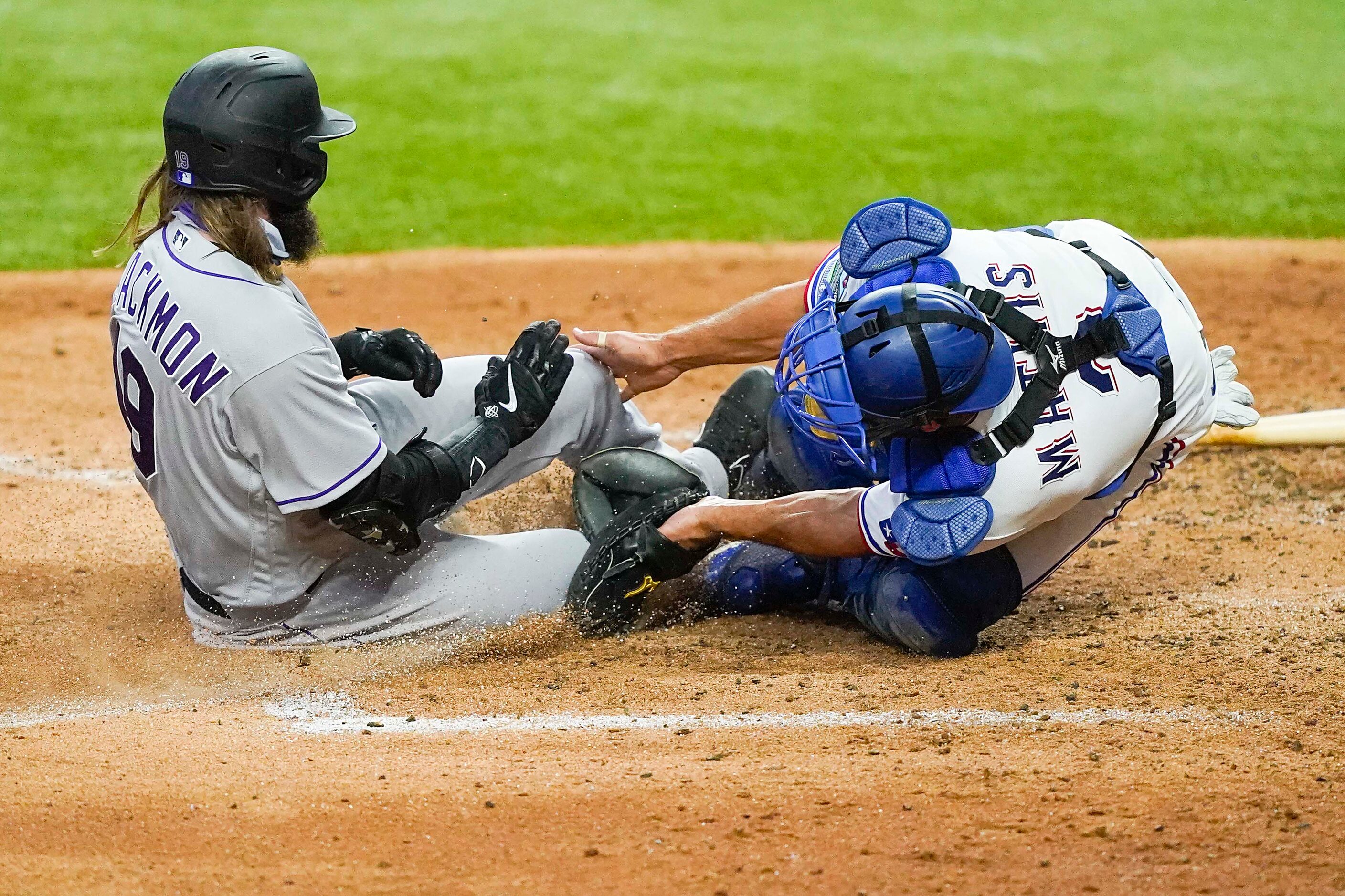 Colorado Rockies outfielder Charlie Blackmon is safe at home as the ball gets away from...